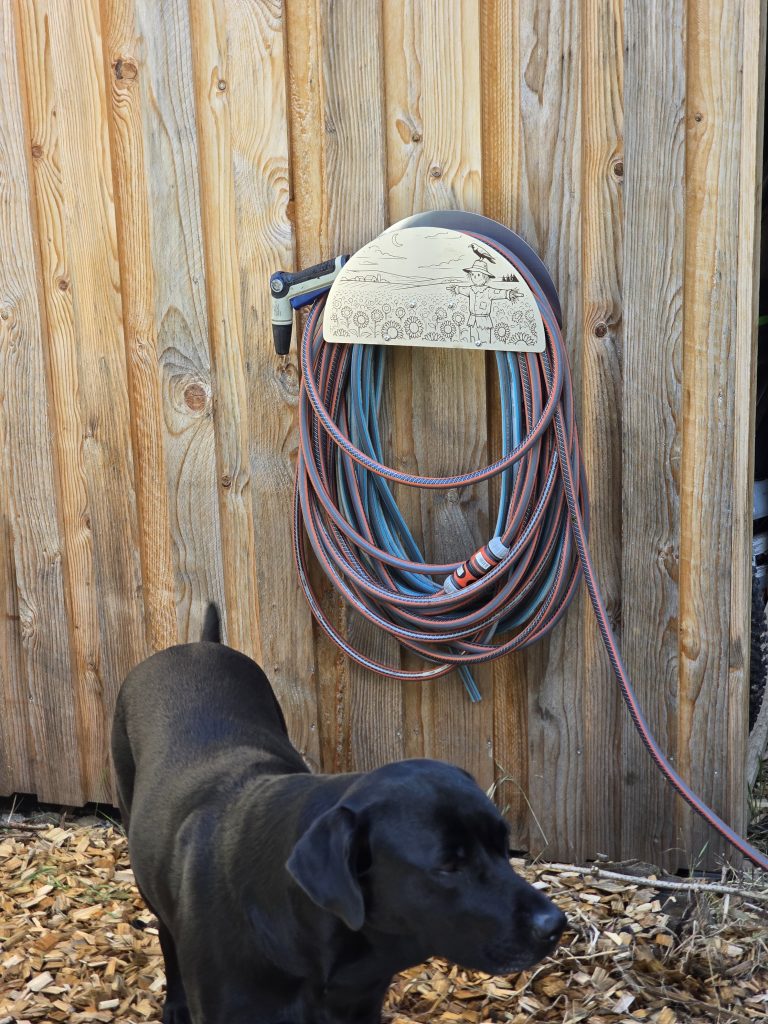 Halter mit aufgewickeltem Schlauch Schlauch Montierter Edelstahl-Schlauchhalter mit mehreren Schlauchwindungen hinter der Frontblende.
