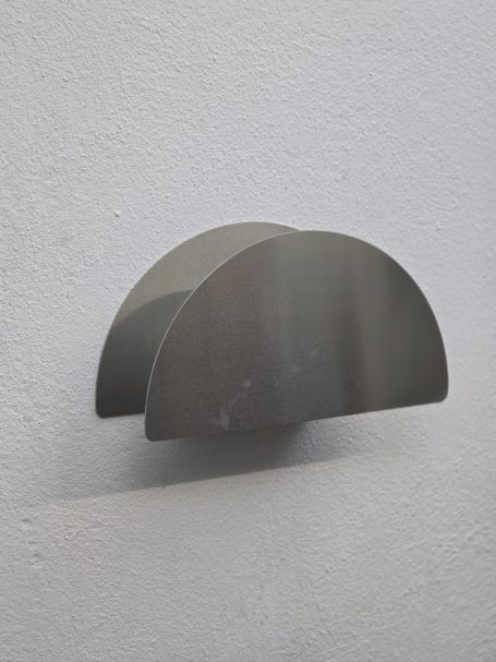 Edelstahl-Schlauchhalter von Stainless Pepper mit geschlossener Frontblende ohne sichtbare Schrauben an einer hellen Wand.